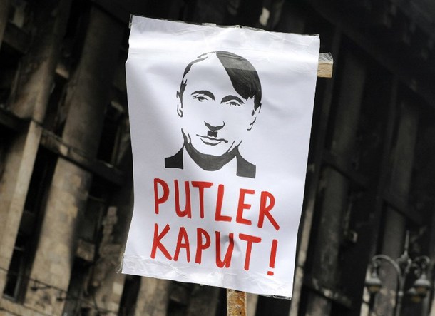 Protest sign of Vladimir Putin with Hitler's mustache and Hitler's hairstyle